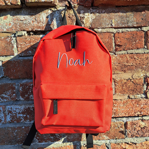 Image of a personalised rucksack for nursery or school which has been personalised with the name Noah in a grey slate embroidery thread. The bag has a main zipped compartment as well as a zipped smaller pocket on the front and two adjustable back straps.