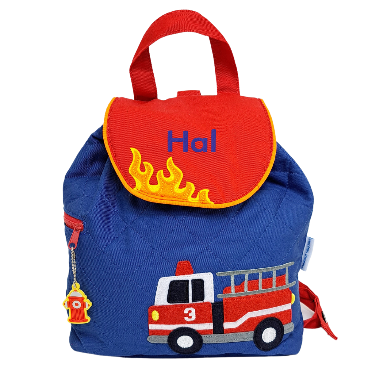 Image of a Stephen Joseph quilted back pack. The main body of the bag is blue with an appliqued fire engine on the front. The flap of the bag is red with orange piping with some yellow and orange flames appliqued along the edge of the flap.