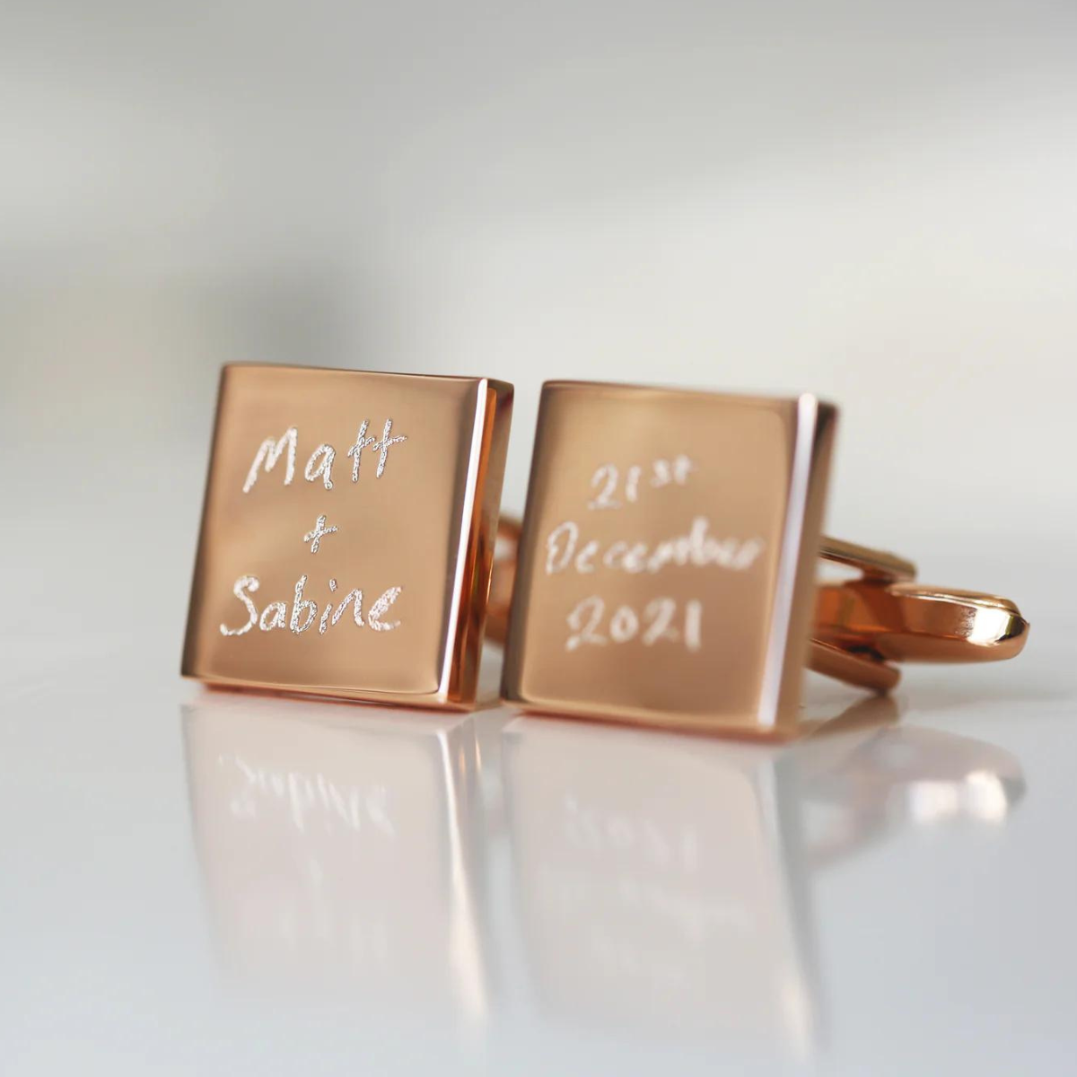 Image of a pair of cufflinks that can each be engraved with your own handwritten message. The cufflinks are available with either a silver or rose gold coloured finish.