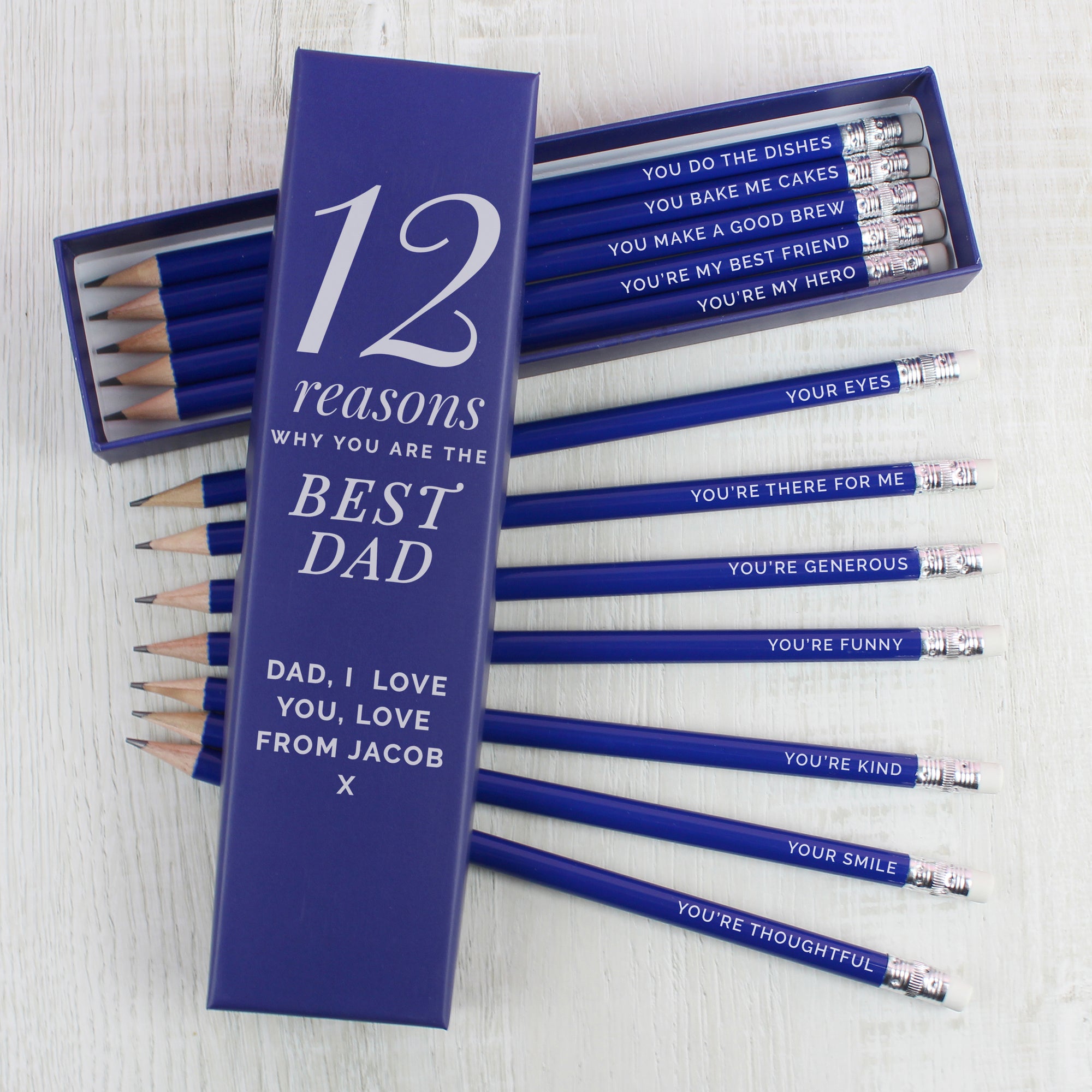 Box of 12 personalised pencils in a blue box. The box has fixed text printed in white which reads '12 reasons' which can be followed by a name and message of your choice which will also be printed in white below that. Inside the box are 12 HB writing pencils with a blue outer and an eraser on the top. Each pencil can be individually personalised with your own reasons why you love someone or other text of your choice.