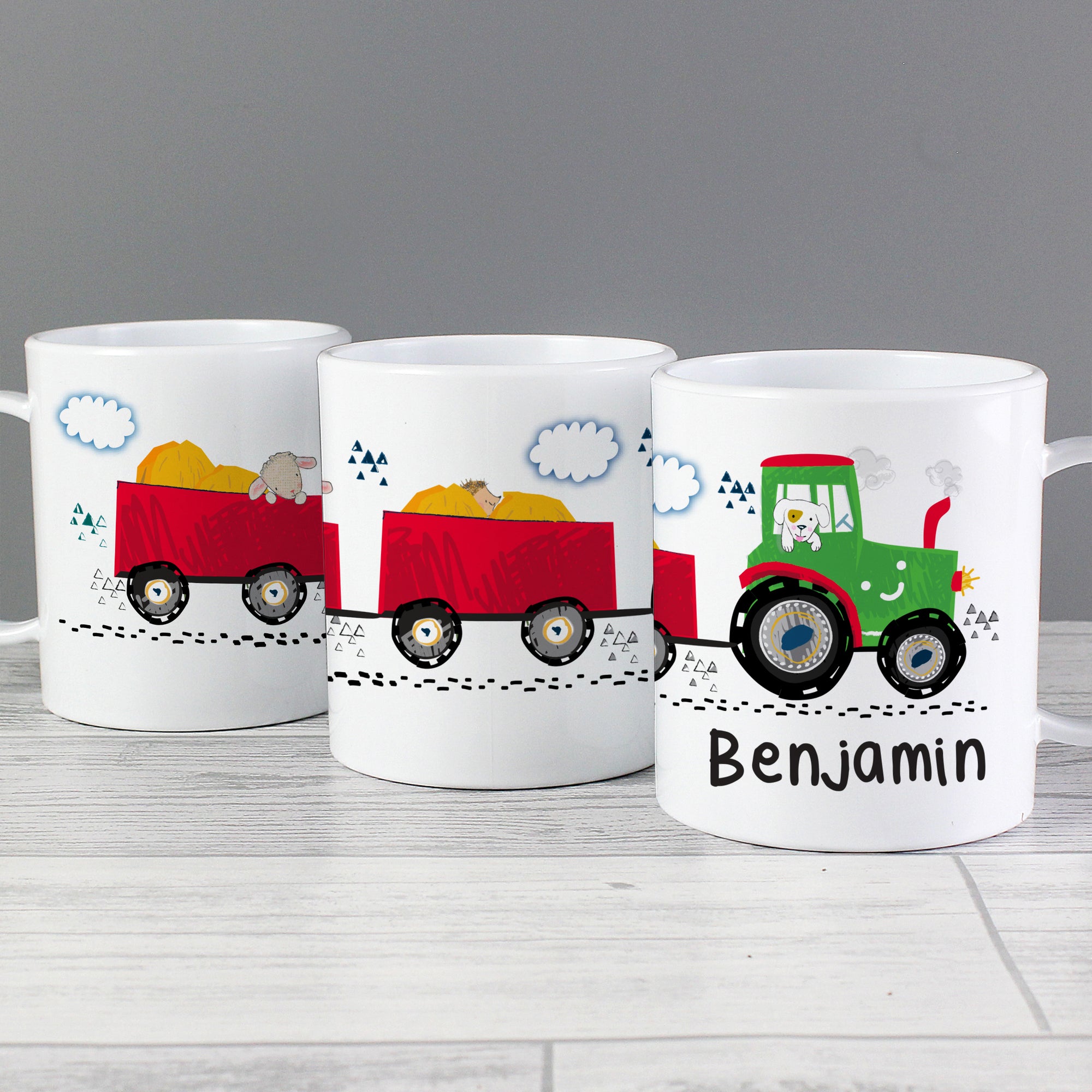 Image of a plastic BPA free childs personalised cup. The cup is white and has an image of a fun cartoon green tractor with a dog in the cab. The tractor is pulling two red trailers that go around at the cup. The cup can be personalised with a name of up to 12 characters which will be printed in black beneath the image of the tractor.