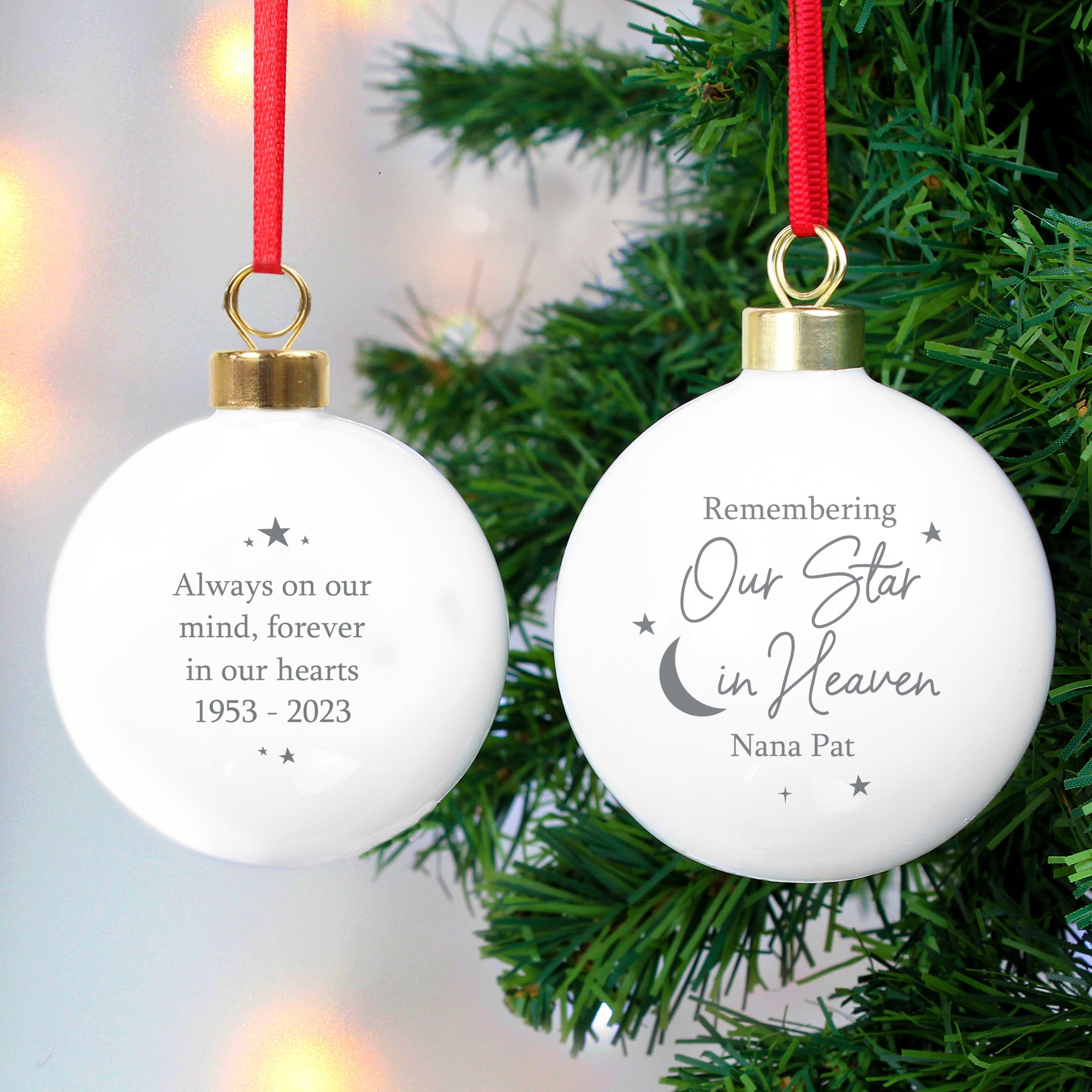 Image of the front and back of a personalised memorial Christmas bauble. The bauble is white and the front features the wording ‘Remembering Our Star in Heaven’ in a great font which is a fixed part of the design and you can add a name of your choice underneath. You can add your own message to the back of the bauble which will be printed in a grey font with some stars around the writing.