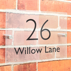 Image of a customised rectangular sign to be attached to a wall outside your house that shows your house number and street name. The sign is made from acrylic and the number and street name are shown in a black modern font which is easy to read.