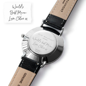 Image of the back of a watch engraved with your own handwriting or the handwriting of a loved one. The watch has a white dial with a silver case and silver details on the watch face, and a black leather strap and part of the Elie Beaumont range of ladies watches.