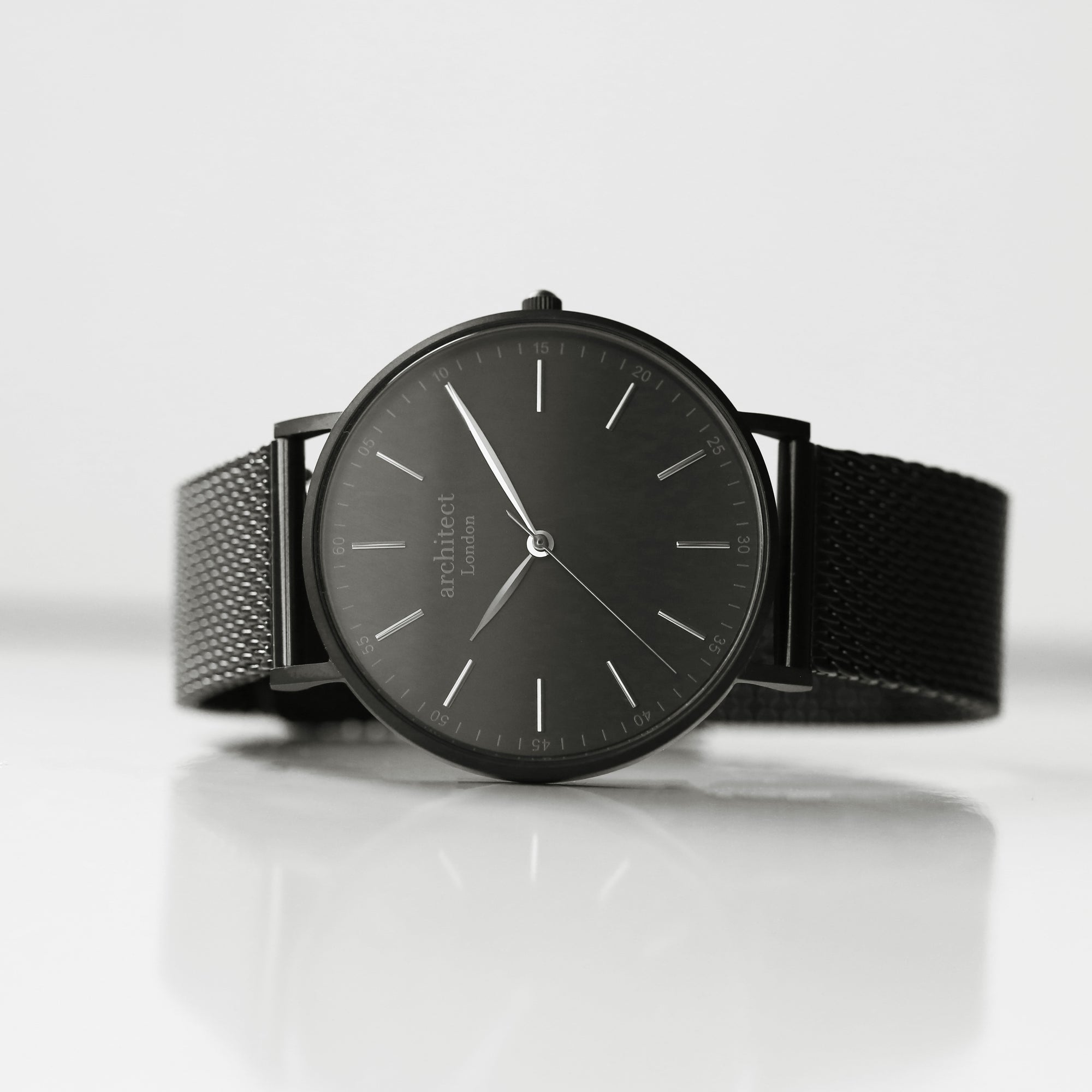 Image of a man's watch by The Architect Watch Company London. The watch has a black dial and a black stainless steel mesh strap. The rear of the watch can be engraved with a message in your own handwriting.