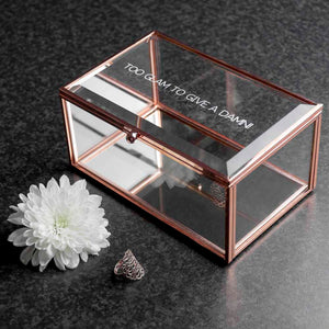 Image of a jewellery box made from rose gold coloured metal and glass with a mirrored bottom. The jewellery box can be personalised with a message of your choice of up to 50 characters which is etched in capital letters in the glass lid of the box.