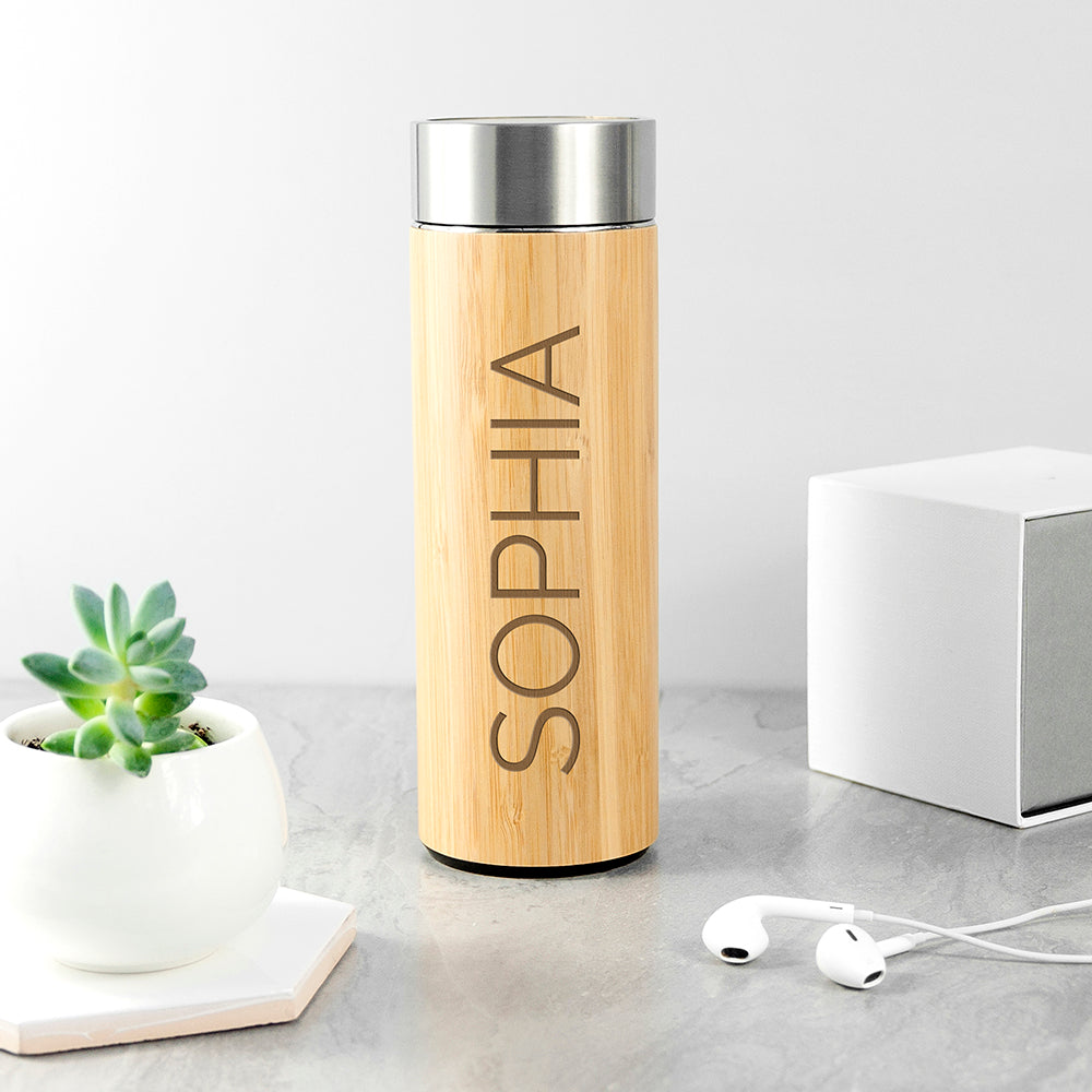 Personalised bamboo vacuum flask with a screw top lid and an optional stainless steel tea strainer insert. The flask is stainless steel double walled insulated and the outside is made from natural bamboo which can be engraved with a name of your choice.