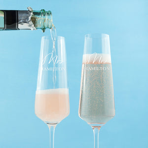 Image of a pair of champagne flutes that can be personalised as Mr/Mr, Mrs/Mrs or Mr/Mrs which will be engraved in a cursive font then a surname of up to 12 characters which will be engraved in an uppercase font.
