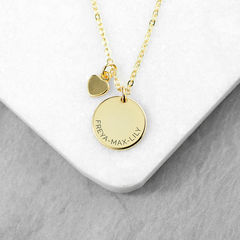 Personalised gold plated necklace with a disc that can be engraved with a name or message of your choice and a small heart charm next to it. The necklace comes with a gold plated necklace.