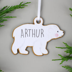 Personalised baby polar bear decoration as part of a family set of two adults and two baby bears. Each bear is painted white and can be personalised with a name of up to 12 characters which will be printed on each bear in a modern grey uppercase font.