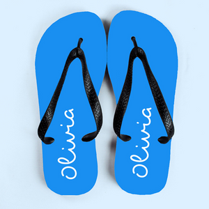 Image of a pair of blue flip flops that have been personalised with a name of your choice of up to 12 characters which will be printed in white. The flip flops have a black strap.