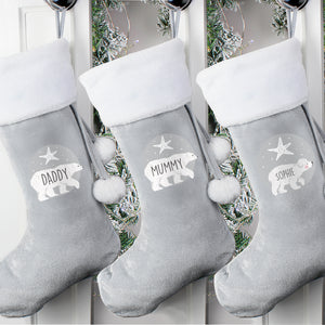 Image of three personalised grey velvet Christmas stockings with plush white trims. The front of two of the stocking features an illustration of a hand-drawn adult polar bear with a star above it and the stocking can be personalised with a name of your choice which will be printed in a black modern uppercase font inside the image of the bear. The third stocking has an image of a baby polar bear which can also be personalised with a name of your choice in the same font.