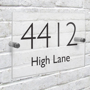 Image of a customised rectangular sign to be attached to a wall outside your house that shows your house number and street name. The sign is made from acrylic and the number and street name are shown in a black modern font which is easy to read.