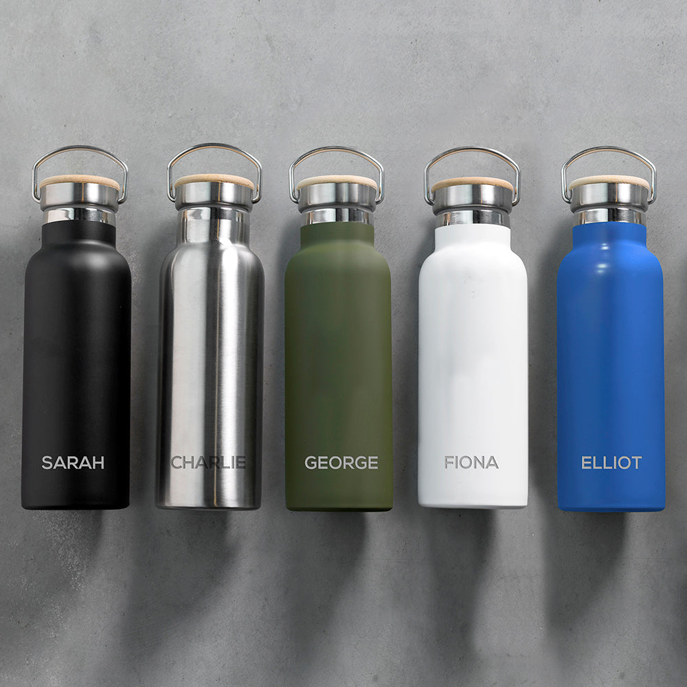 Personalised insulated drinks bottles with bamboo vacuum sealed lids and a carry handle available in matt black, stainless steel, matt green, matt white and matt blue. The bottle can be personalised with a name of your choice which will be engraved in uppercase.