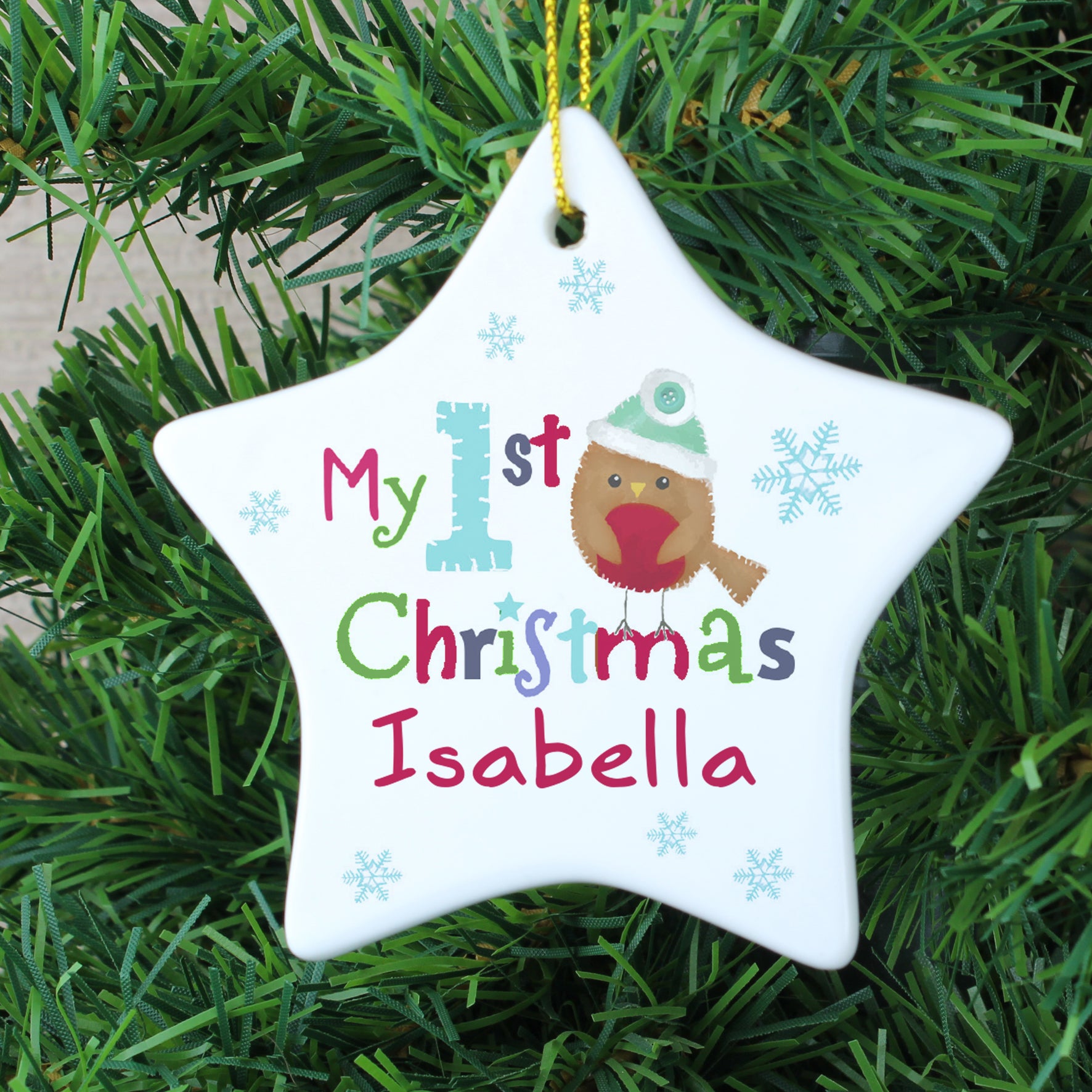 Personalised white ceramic star shaped Christmas decoration to hang on a tree featuring the words 'My 1st Christmas' on the front alongside an image of a hand-drawn robin. The front of the decoration can be personalised with a name of your choice of up to 12 characters.