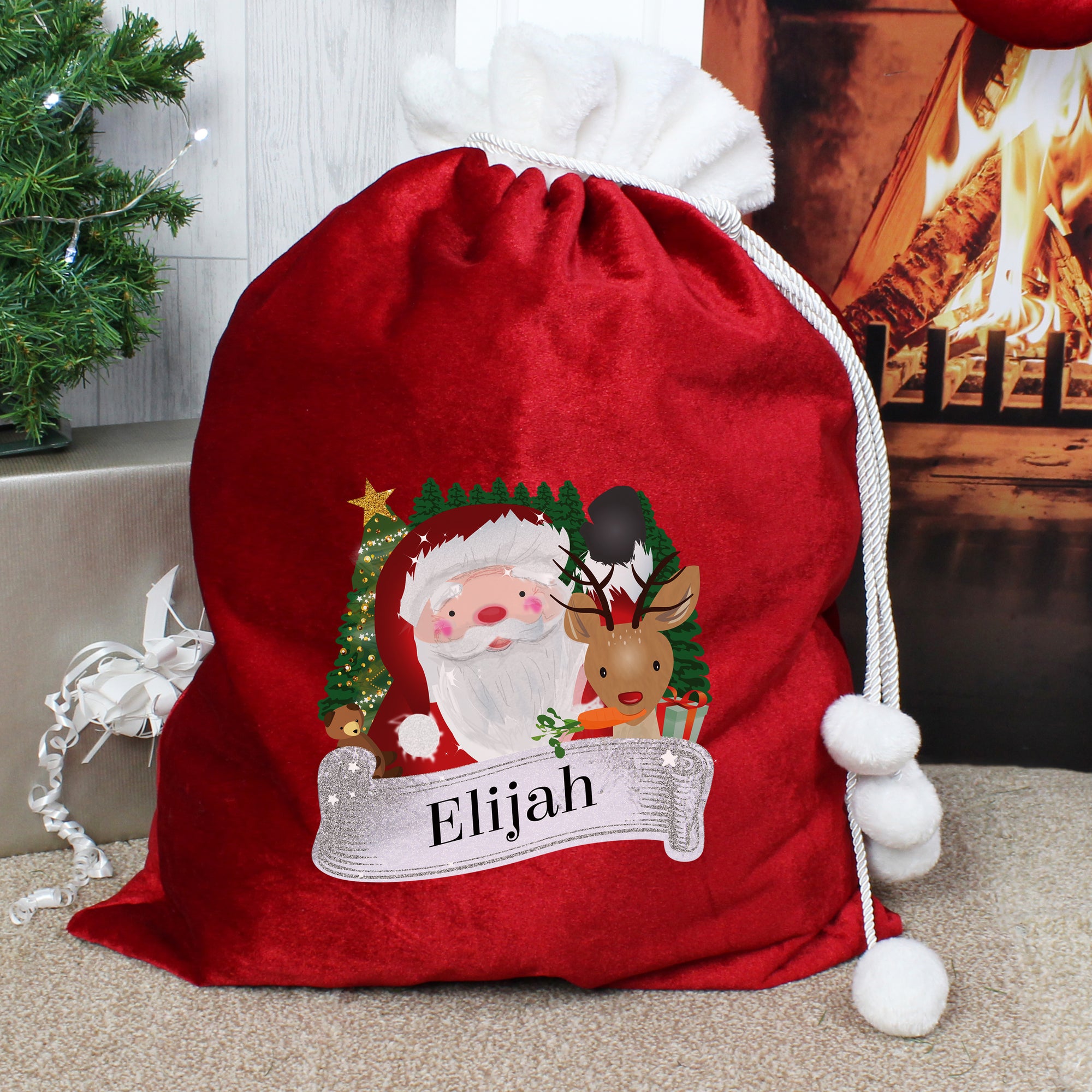 Personalised soft red velvet Christmas present sack featuring a cartoon illustration of Santa and the wording Merry Christmas. There is a white fur cuff on the top of the sack. The front of the sack can be personalised with a name of your choice of up to 12 characters which will be printed just below the illustration of Santa in a black font.