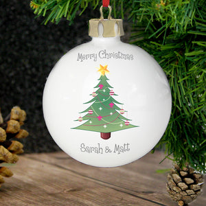 Personalised round white ceramic Christmas tree bauble featuring a drawing of a Christmas tree on the front.  The bauble can be personalised with two lines of your own text on the front of the bauble, one line above the tree and the other line below the tree. You can also add your own message over up to 4 lines on the back.
