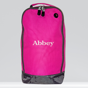 Image of a personalised sports shoe and accessories bag. The bag is fuchsia pink and can be personalised wtih an embroidred name of your choice in a range of different colours.  The bag is made from water resistant fabric and has a wipe clean interior. The bag has a ventilation hole and a mesh pocket on the bag of the bag as well as a carry handle and a zip.