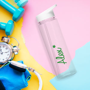 Image of a transparent reuseable water bottle lying on its side on a pink, blue and yellow abstract background, next to some dumb bells, a clock and headphones. The bottle is made from BPA free transparent hard-wearing plastic with a white screw on lid with a flip up spout.  The outside of the bottle can be personalised in a name of your choice which will be printed in a green font on the side of the bottle with a green star above the last letter of the name.