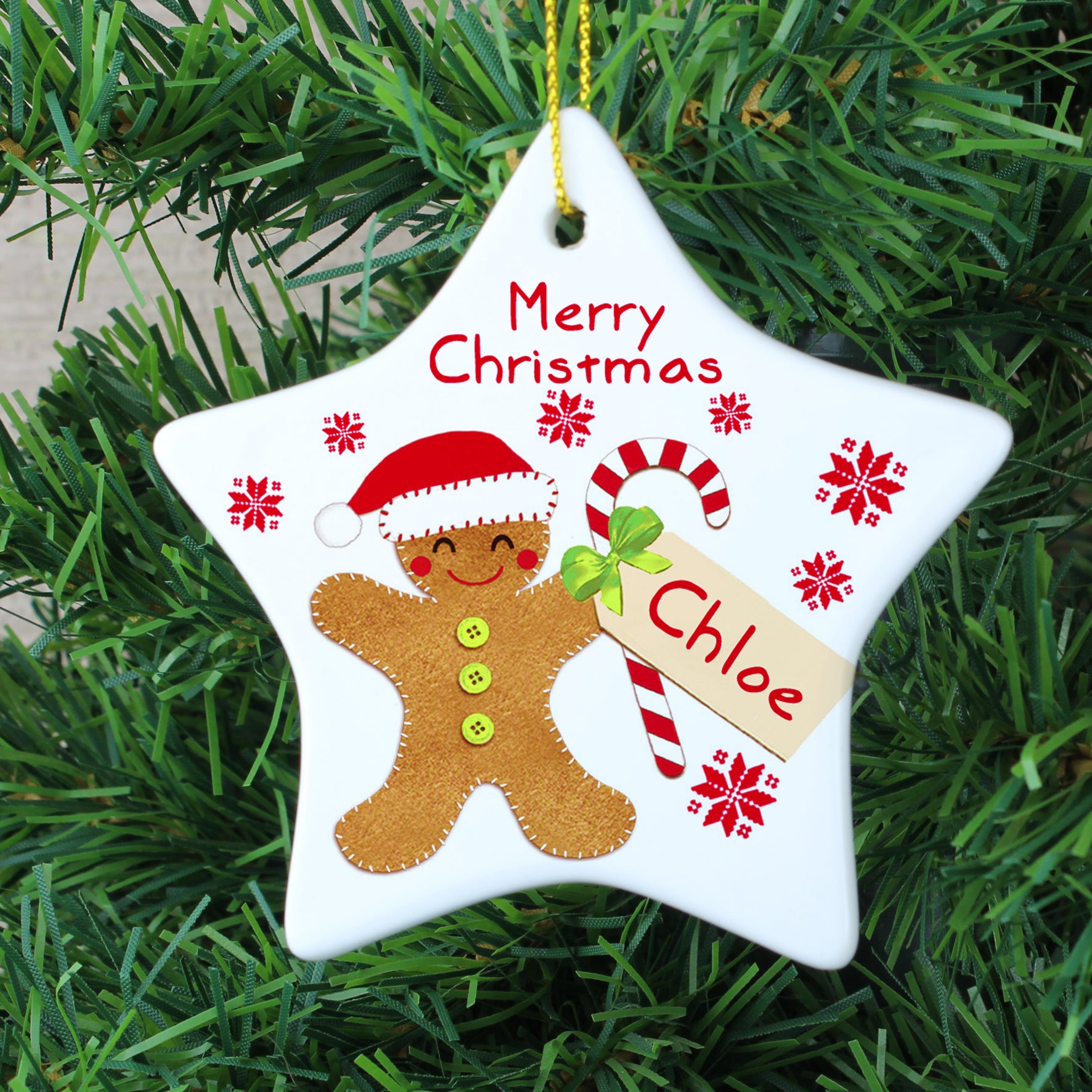 Personalised white ceramic star shaped Christmas decoration featuring an image of a hand-drawn gingerbread man holding a candy cane which can be personalised with a name of your choice.