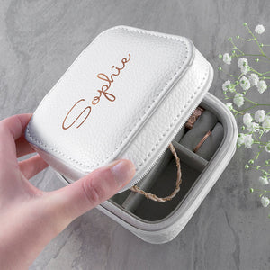 Image of a white leather square travel jewellery case that can be personalised with a name of your choice of up to 15 characters on the lid in a choice of colours and 3 different fonts. The case closes securely with a white zip and internally has flock lined compartments for storing jewellery.