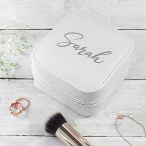 Image of a white leather square travel jewellery case that can be personalised with a name of your choice of up to 15 characters on the lid in a choice of colours and 3 different fonts. The case closes securely with a white zip and internally has flock lined compartments for storing jewellery.