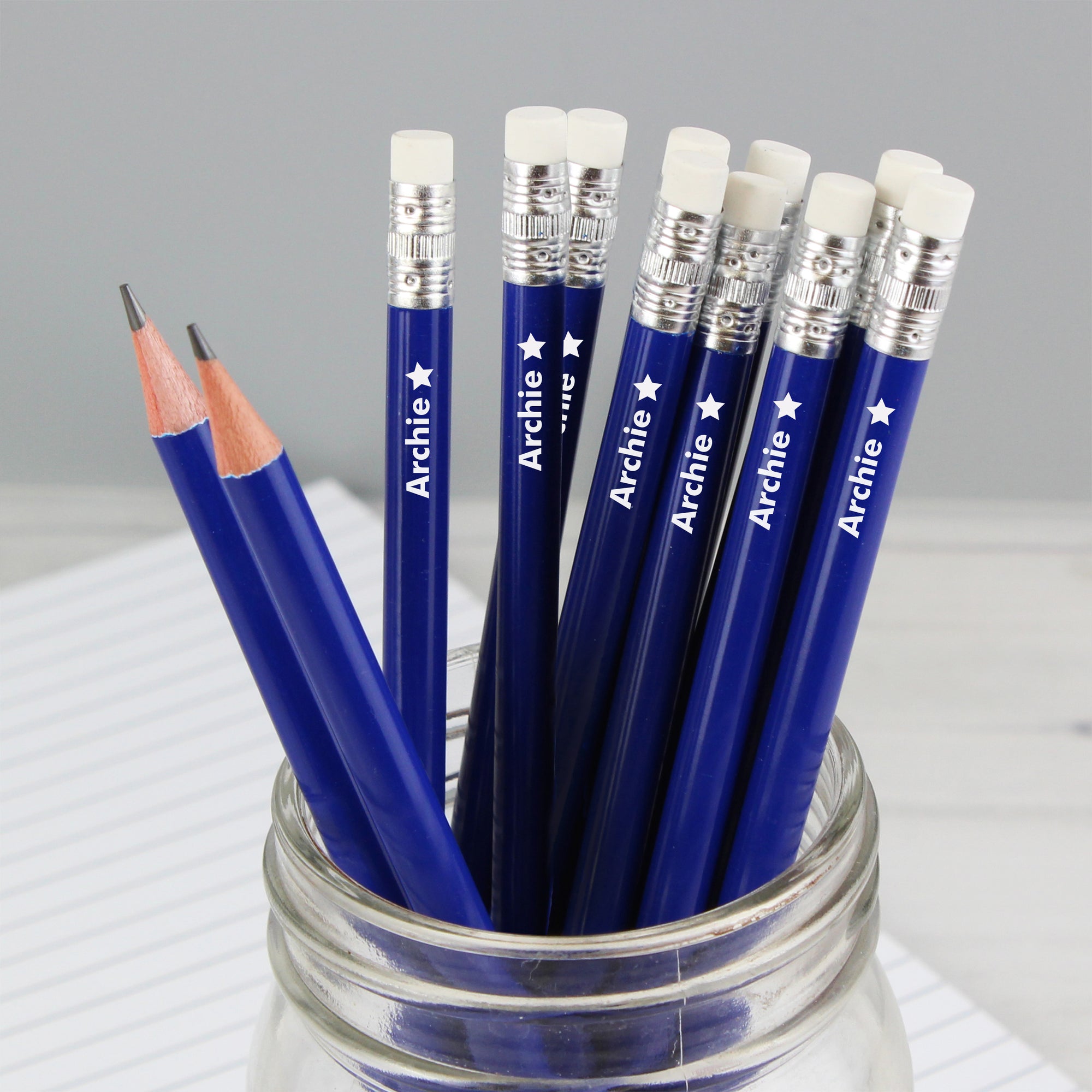 Image of a pack of 12 HB blue writing pencils that can be personalised with a name of your choice with a little star motif printed after the name.